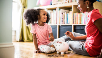 mother-and-daughter-putting-money-in-piggybank-6389327