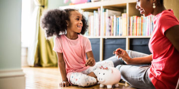 mother-and-daughter-putting-money-in-piggybank-6389327